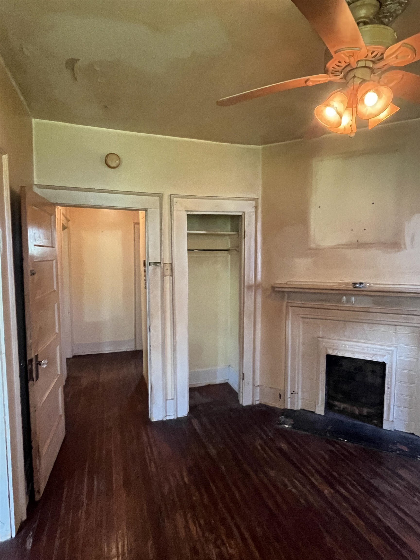 211 4th Street Mobile, AL 36611 - Photo 8 of 34 Unfurnished living room with dark wood-style floors, ceiling fan, and a fireplace with flush hearth