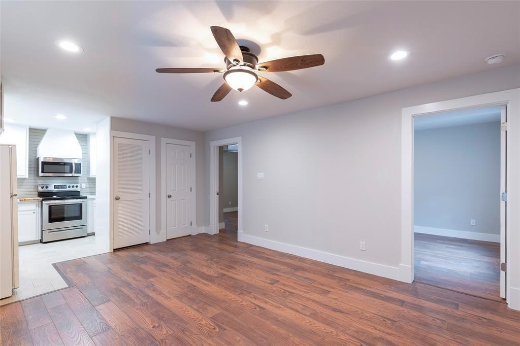 640 Columbia Street, Unit 1/2A Houston, TX 77007 - Photo 2 of 9 a view of an empty room with wooden floor and a ceiling fan