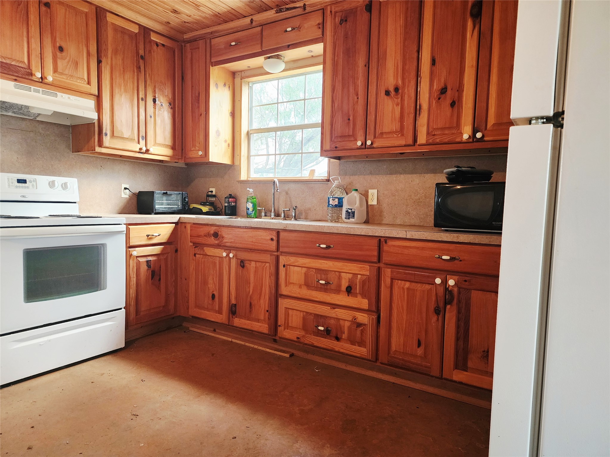Tbd Tbd 1480th San Saba, TX 76877 - Photo 18 of 29 Kitchen with white appliances, brown cabinetry, under cabinet range hood, and light countertops