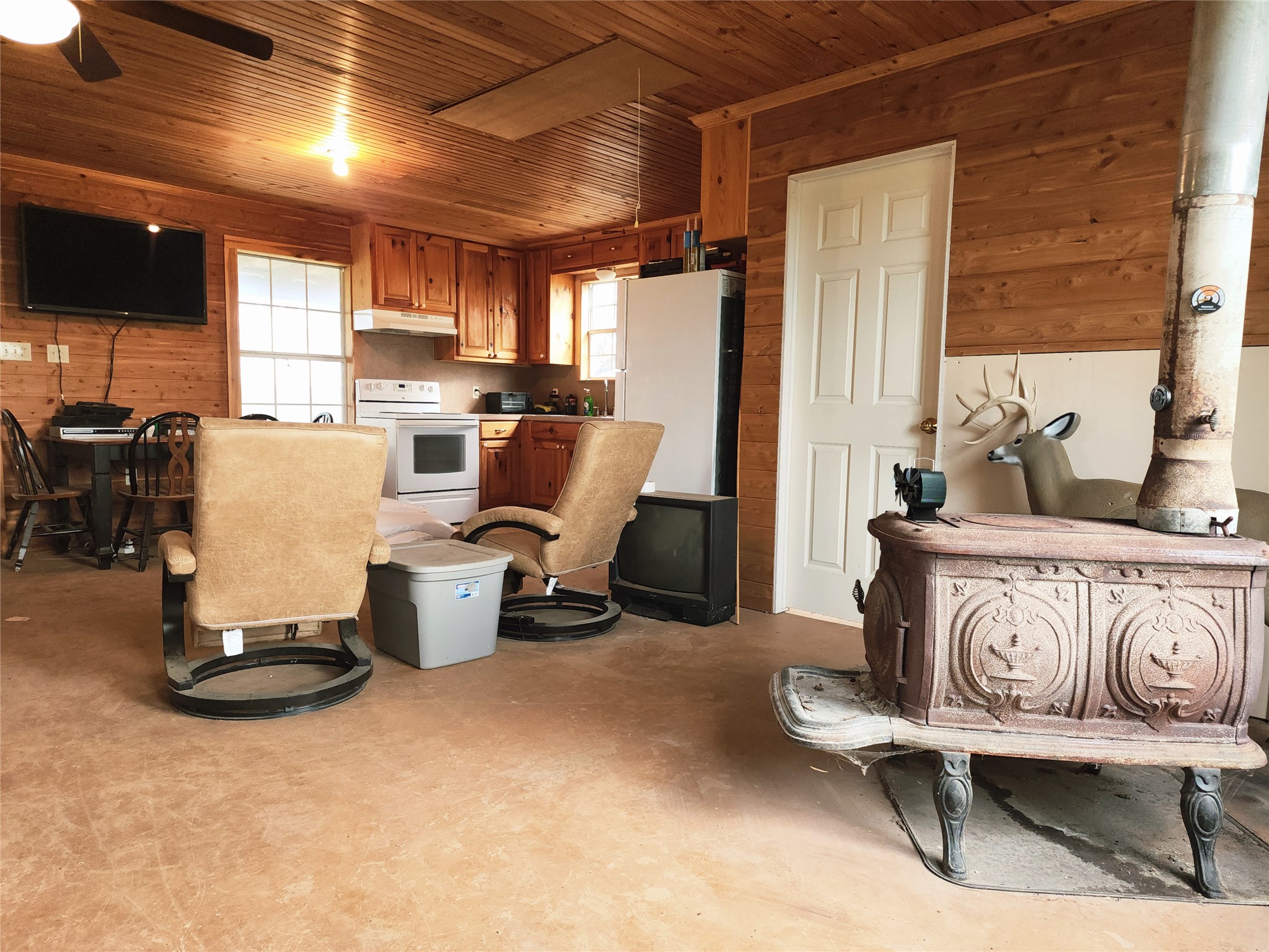 Tbd Tbd 1480th San Saba, TX 76877 - Photo 24 of 29 Kitchen with wood walls, brown cabinetry, wood ceiling, white appliances, and under cabinet range hood