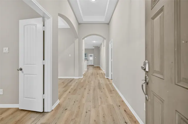 a view of a hallway with wooden floor and staircase
