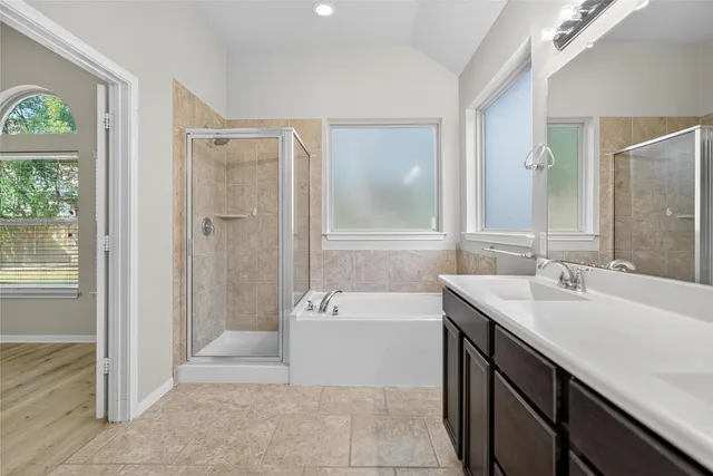 a spacious bathroom with a tub sink and mirror