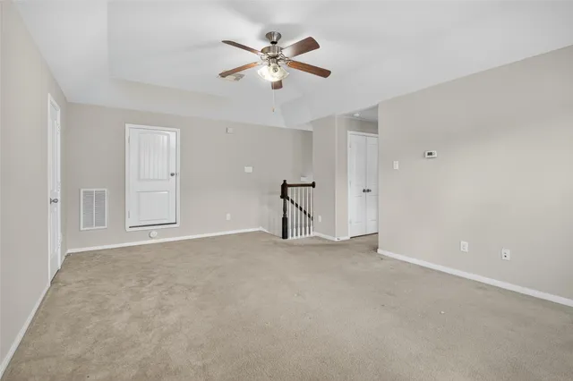 a view of an empty room with a ceiling fan
