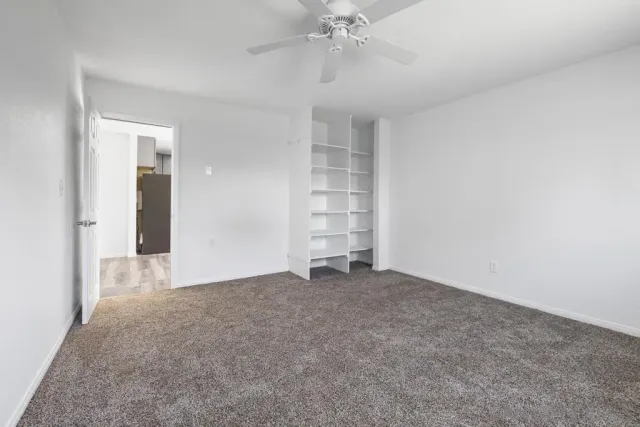 an empty room with closet and windows