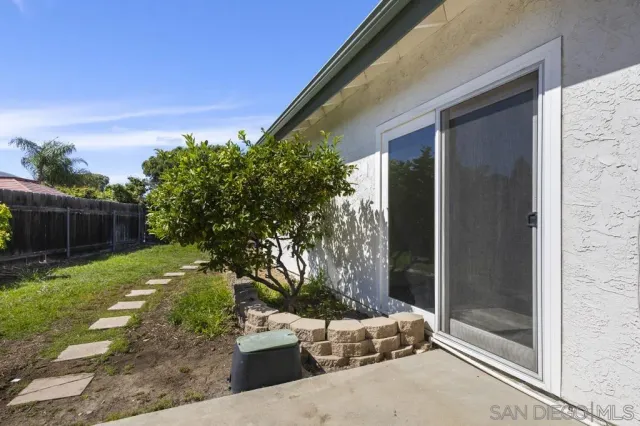 a patio with table and chairs and potted plants