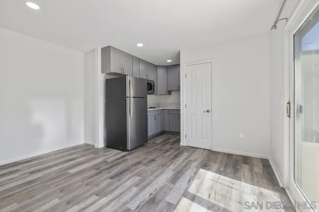 a view of kitchen with refrigerator and wooden floor