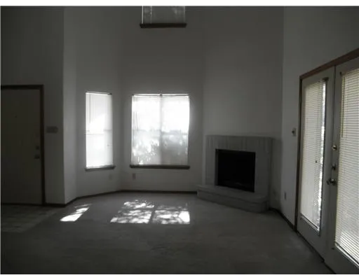 a view of an empty room with a fireplace and large window