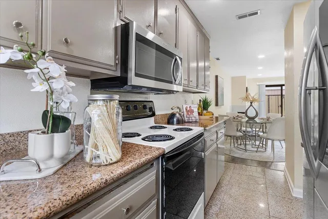 a kitchen with stainless steel appliances granite countertop a stove a sink and a microwave