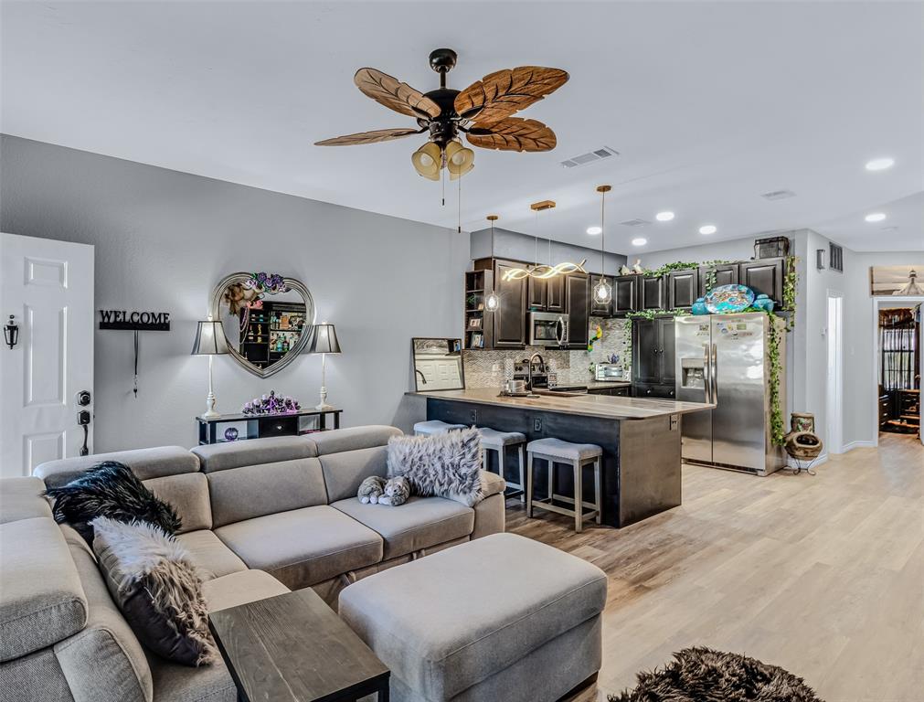 a living room with furniture kitchen view and a chandelier