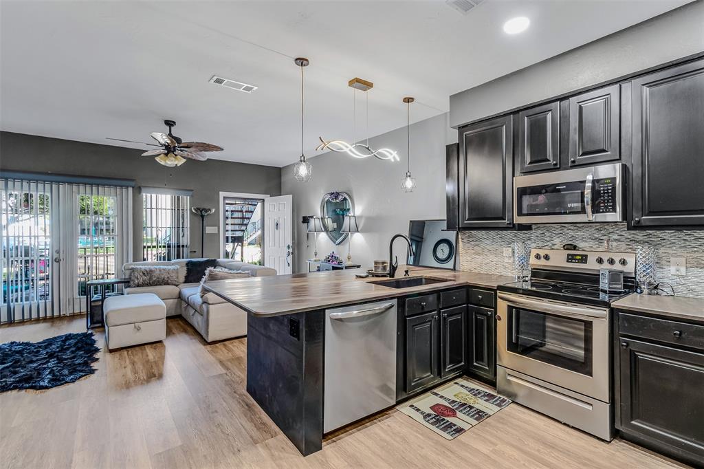 1933 Island Circle, Unit B106 Tool, TX 75143 - Photo 7 of 12 a kitchen with stainless steel appliances granite countertop a sink stove and cabinets