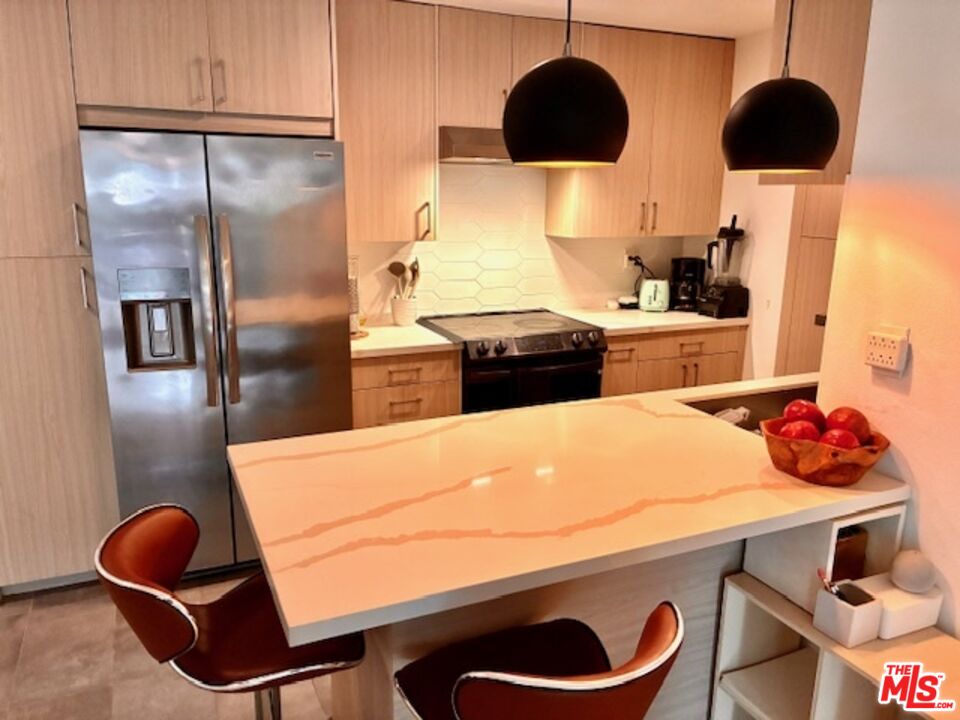 a kitchen with stainless steel appliances granite countertop a sink a stove and refrigerator