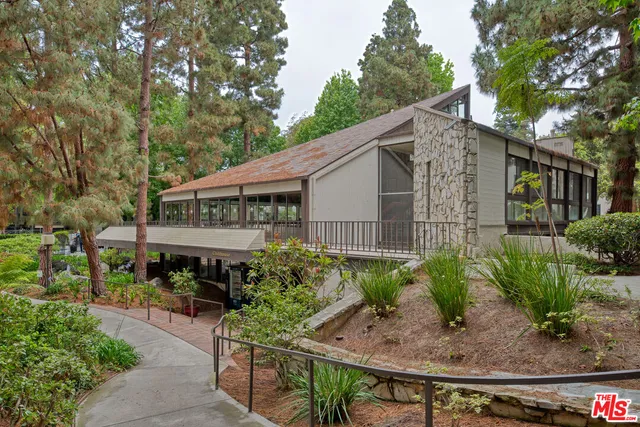 a backyard of a house with plants and outdoor seating