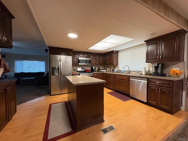 a kitchen with kitchen island granite countertop a sink counter top space and stainless steel appliances