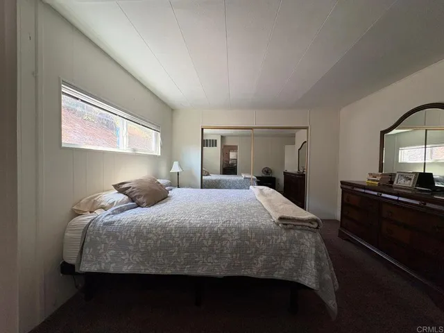 a bedroom with a bed and a large mirror