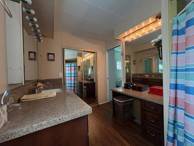 a en suite bathroom with a granite countertop sink and a mirror