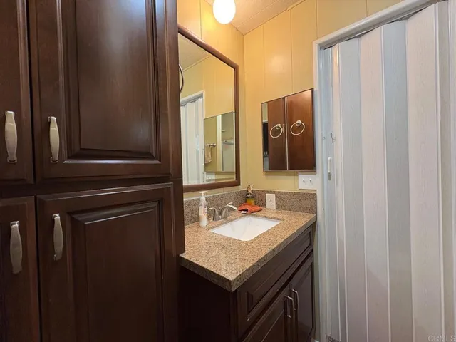 a bathroom with a granite countertop sink toilet and shower