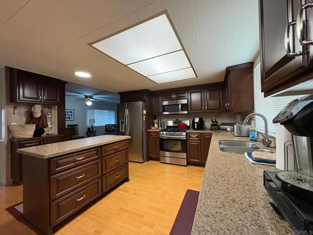 a kitchen with stainless steel appliances granite countertop a stove sink and cabinets