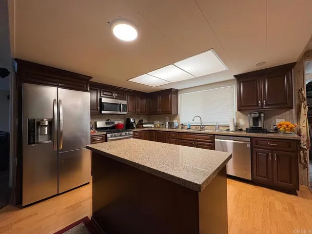 a kitchen with granite countertop a refrigerator and a sink