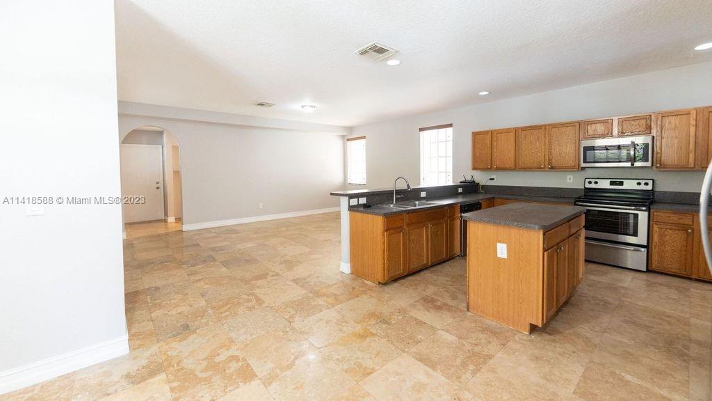 13962 Southwest 278th Street Homestead, FL 33032 - Photo 12 of 45 a kitchen with stainless steel appliances granite countertop a stove top oven and sink