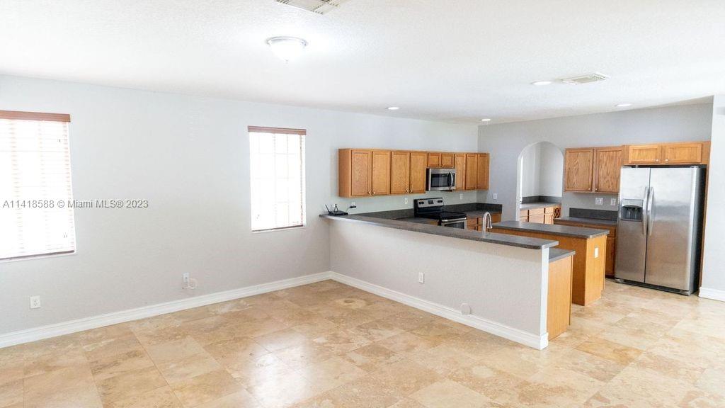 13962 Southwest 278th Street Homestead, FL 33032 - Photo 14 of 45 a kitchen with granite countertop a refrigerator sink and cabinets