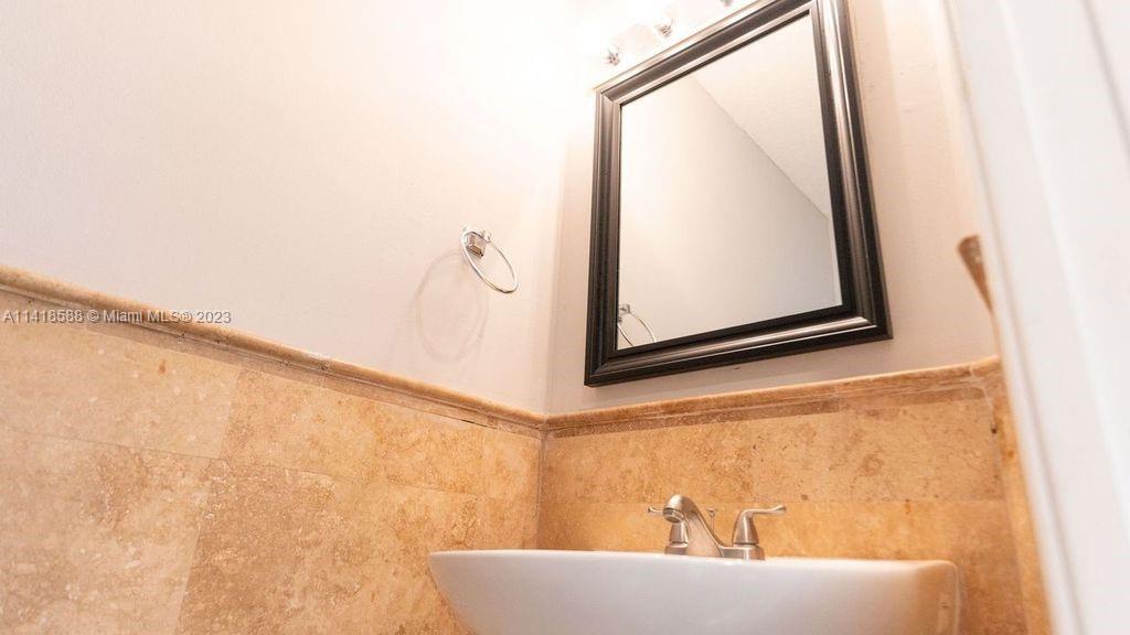 13962 Southwest 278th Street Homestead, FL 33032 - Photo 37 of 45 a bath tub sitting next to a white sink and a mirror