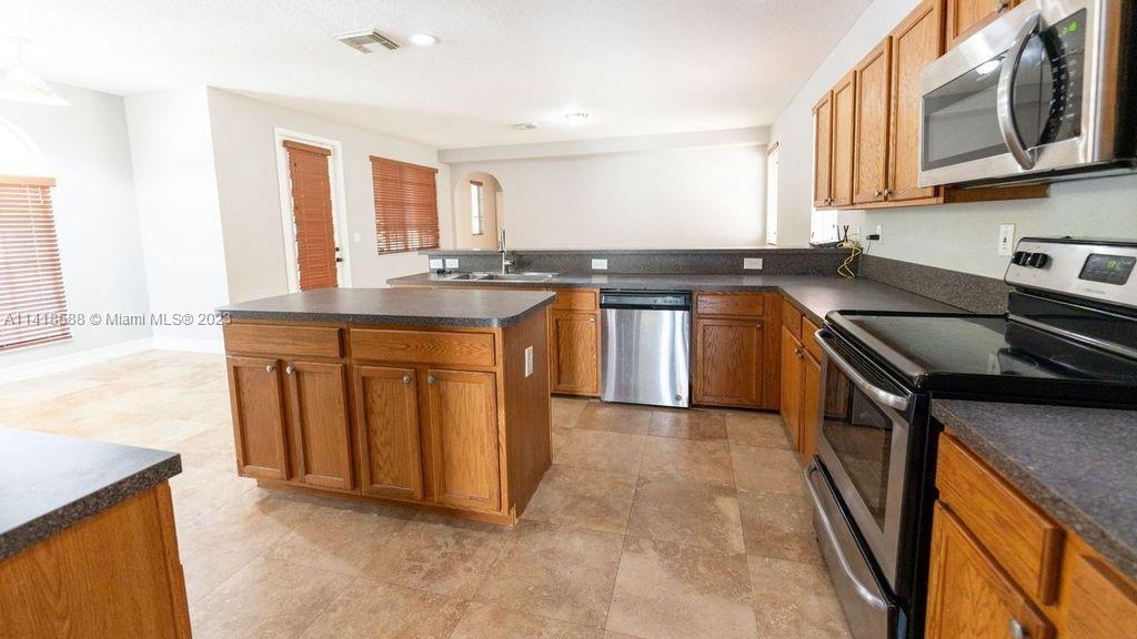 13962 Southwest 278th Street Homestead, FL 33032 - Photo 10 of 45 a kitchen with stainless steel appliances granite countertop a stove a sink and a microwave
