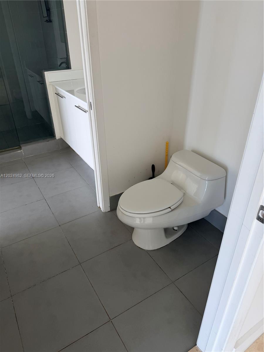 92 Southwest 3rd Street, Unit 3909 Miami, FL 33130 - Photo 4 of 13 a white toilet sitting next to a white sink and vanity