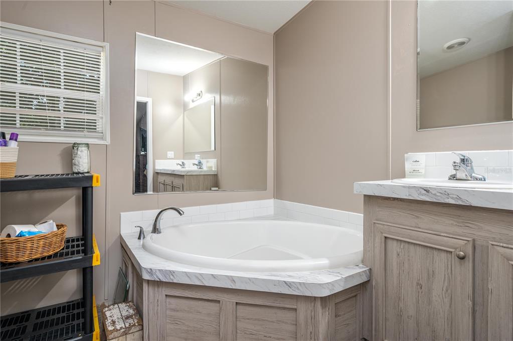 15079 Brahma Road Polk City, FL 33868 - Photo 10 of 40 a bathroom with a tub sink and mirror