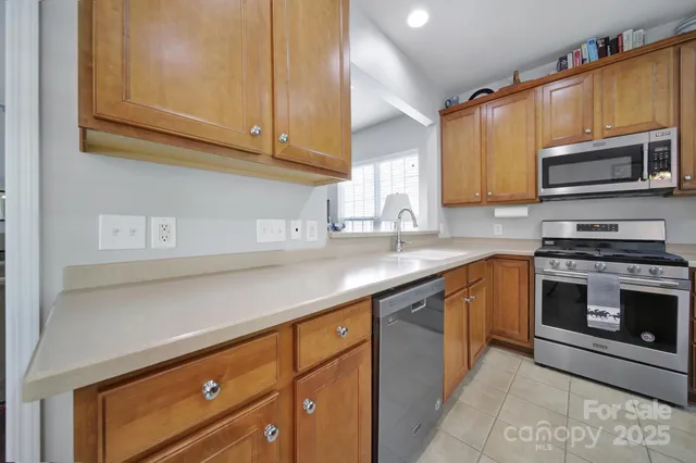 a kitchen with stainless steel appliances granite countertop a sink a stove a microwave and cabinets