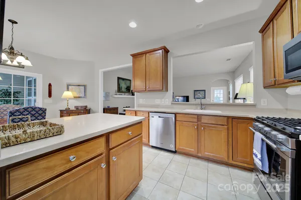 a kitchen with stainless steel appliances granite countertop a sink stove and cabinets