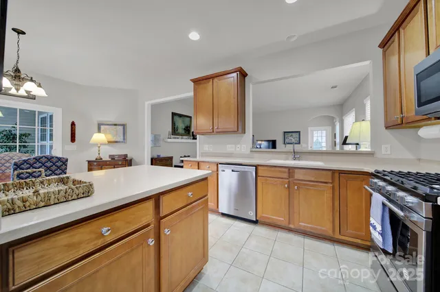 a kitchen with stainless steel appliances granite countertop a sink stove and cabinets