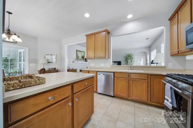 a kitchen with stainless steel appliances granite countertop a sink stove and cabinets