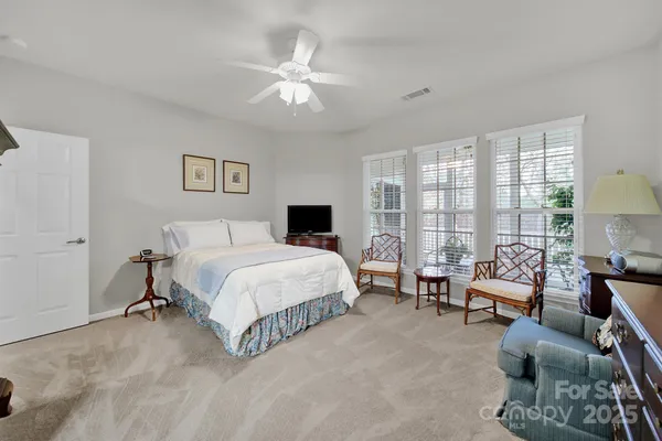 a spacious bedroom with a bed and a chandelier