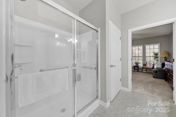 a view of a livingroom with a furniture a ceiling fan and windows