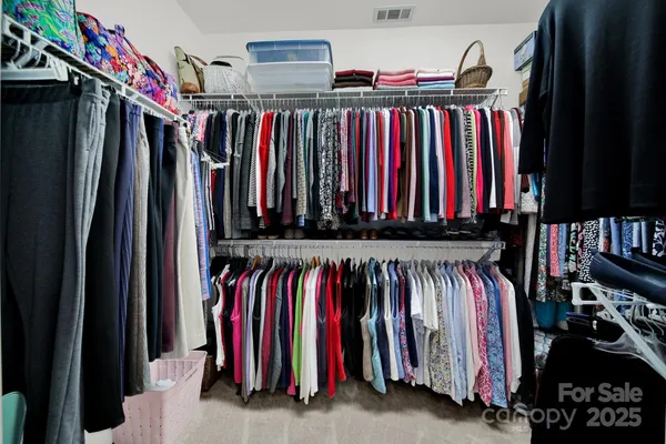 a view of walk in closet with clothes