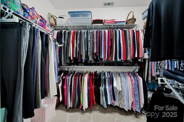 a view of walk in closet with clothes