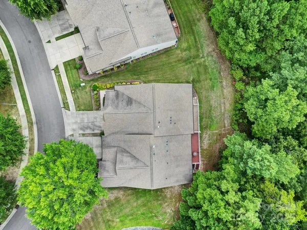 an aerial view of a house with a yard and large tree
