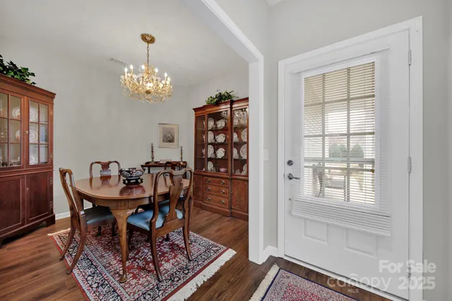 a view of a dining room with furniture a rug and wooden floor