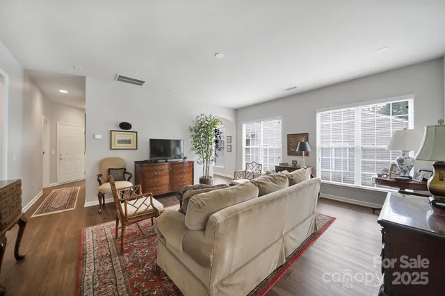 a living room with furniture large window and a table