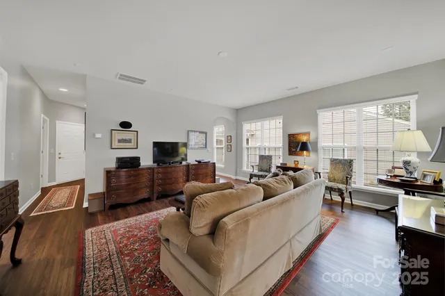 a living room with furniture flat screen tv and window