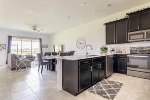 a kitchen with stainless steel appliances a table chairs and a refrigerator