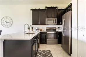 a kitchen with stainless steel appliances kitchen island granite countertop a refrigerator and a stove top oven