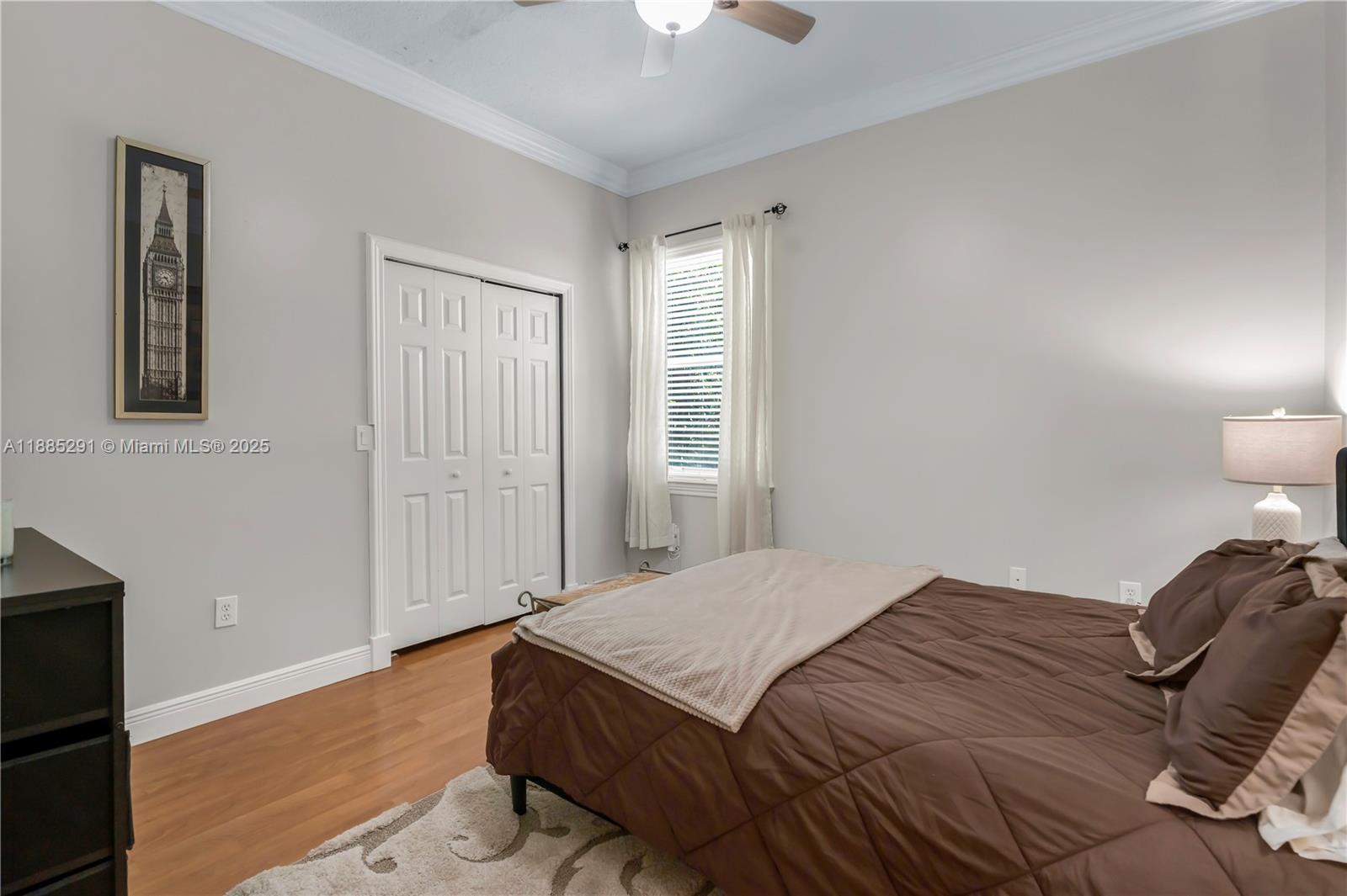 4166 Southwest 190th Avenue Miramar, FL 33029 - Photo 29 of 70 a bedroom with a bed and a lamp with wooden floor