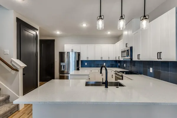 a kitchen with stainless steel appliances kitchen island a refrigerator and a sink