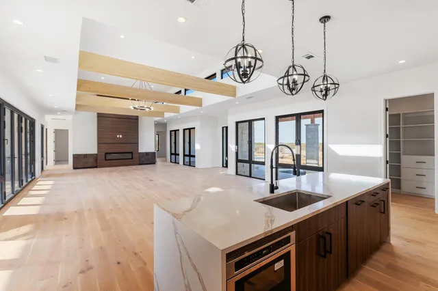 a kitchen with stainless steel appliances granite countertop a sink a oven and wooden floors