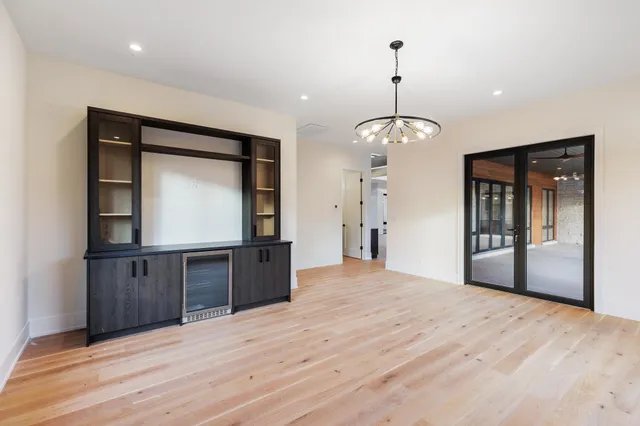 a view of an empty room with window and wooden floor