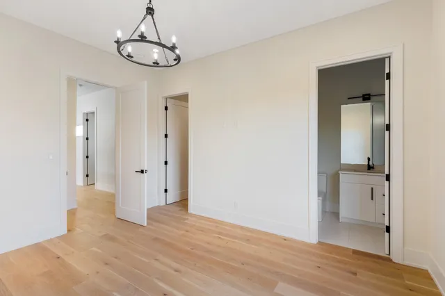 a view of empty room with wooden floor and ceiling fan
