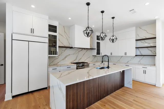 a kitchen with stainless steel appliances granite countertop a sink a stove and a refrigerator