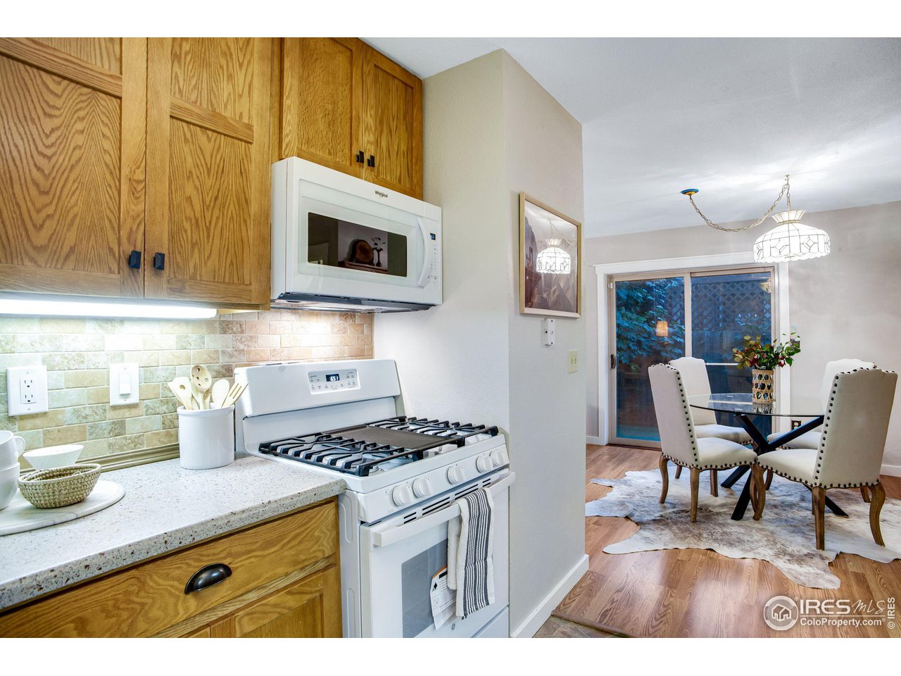 60 Lodgepole Drive Windsor, CO 80550 - Photo 12 of 27 a kitchen with stainless steel appliances granite countertop a stove a sink dishwasher and a microwave with wooden floor