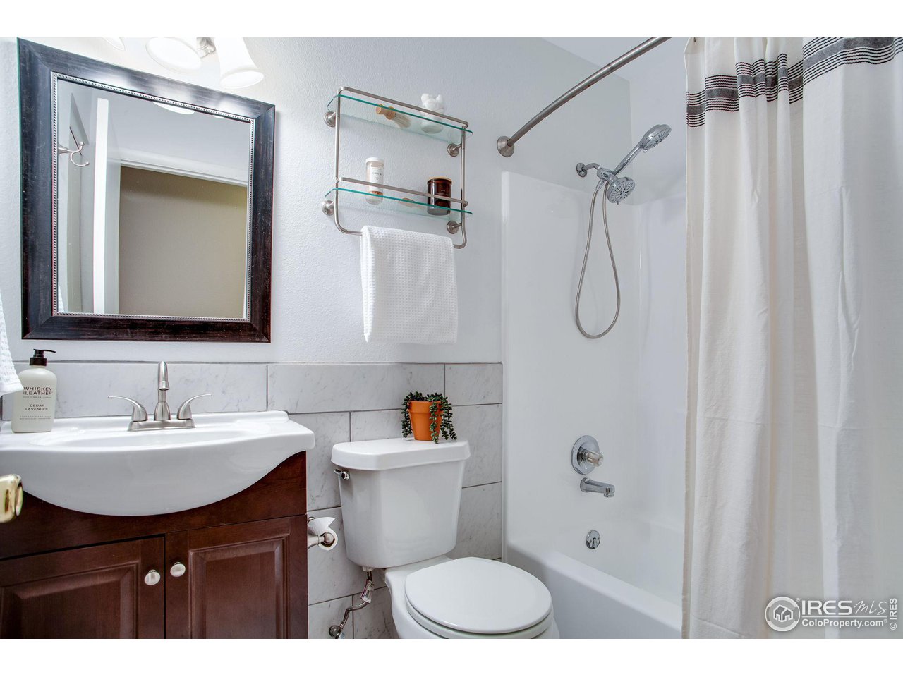60 Lodgepole Drive Windsor, CO 80550 - Photo 19 of 27 a bathroom with a sink toilet a mirror and shower